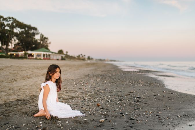 girl sitting on beach in daylight