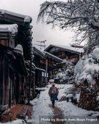 Back view of Japanese person walking in snow-covered alley in Japan 4A9NN4