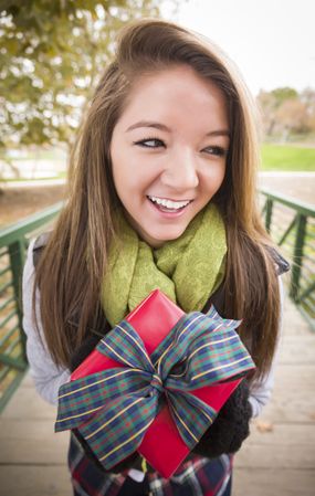 Woman with Wrapped Gift and Bow Outdoors