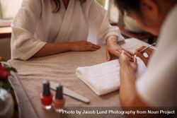 Woman getting her nails done by a manicurist bxAdzd