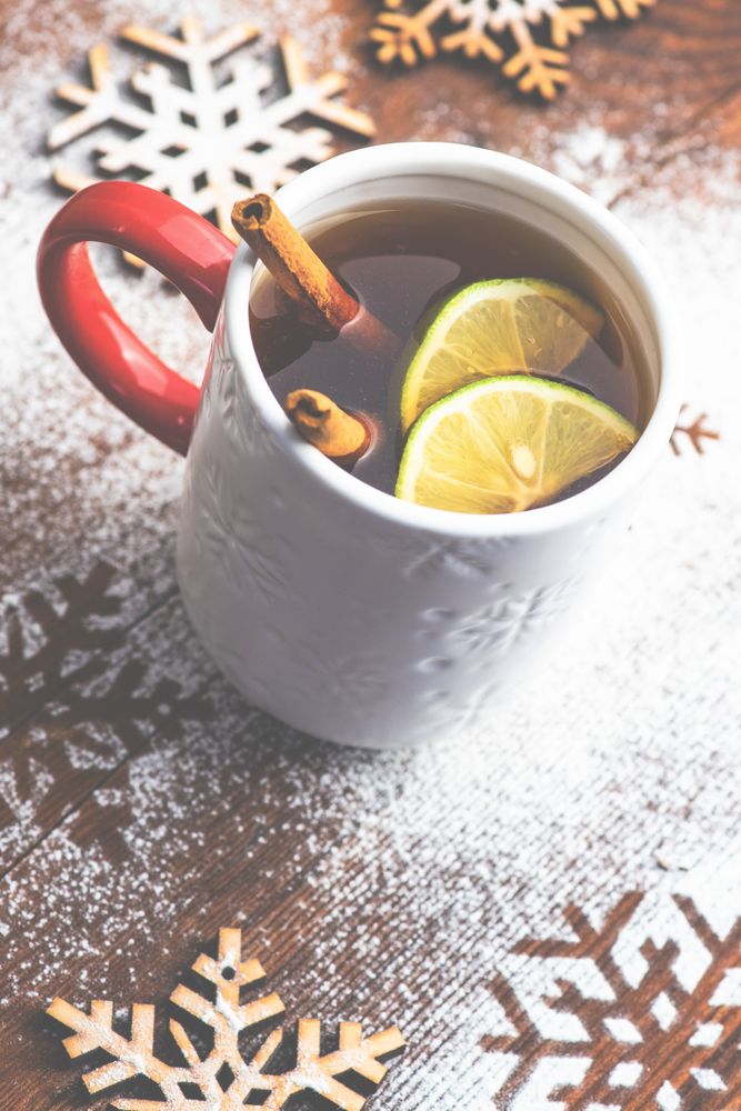Warm Christmas drink with citrus slice and cinnamon stick