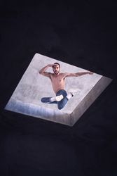 Young man jumping while practicing breakdance in shabby construction