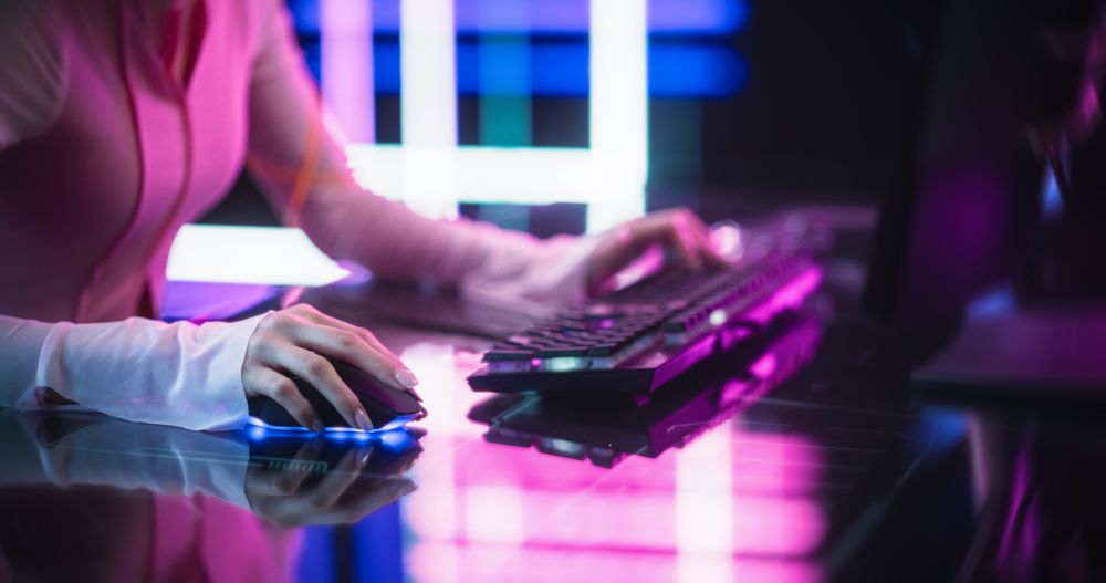 Streamer Sitting Behind a Futuristic Interactive Desk in a Colorful Neon Studio Room