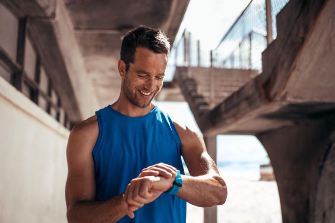 Smiling man using a smartwatch to monitor his progress