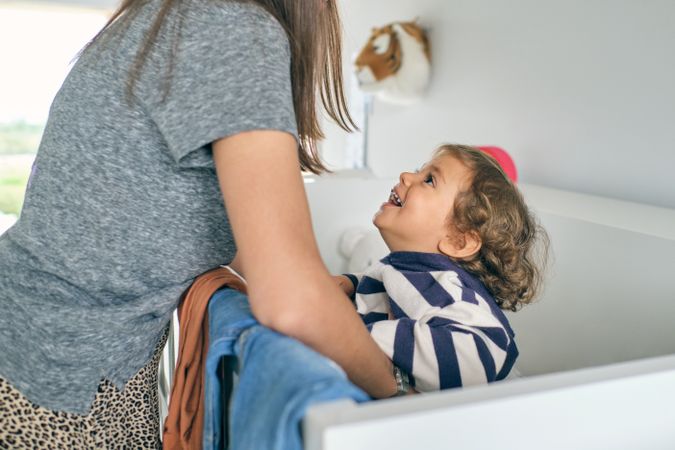 Mother looking at little son in crib