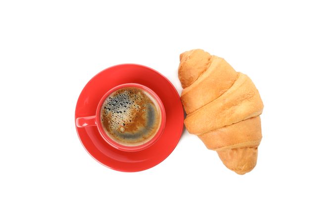 Top view of cup of coffee and croissant isolated on plain background