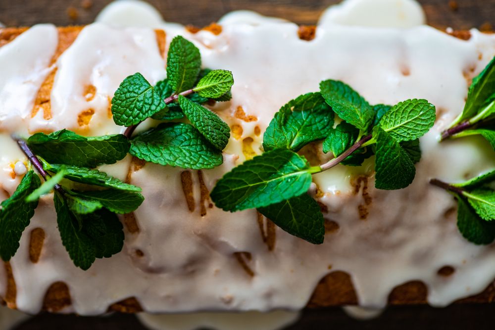 Close up of top of homemade lemon cake with fresh mint garnish
