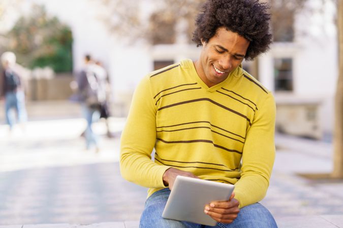 Man sitting outside using tablet