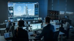 Mission Control Center Monitors Rocket Launch. Engineers Analyze Data on Multiple Screens Displaying Spacecraft, Telemetry, and Launch Pad.