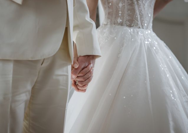 Delicate details of the wedding celebration. Newlyweds hold hands.