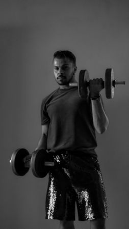 South Asian carrying two dumbbells