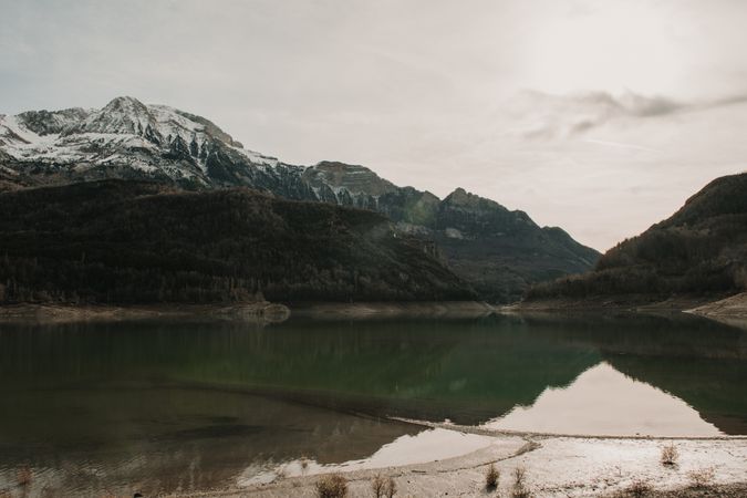 Wonderful lake between hills in snow and cloudy sky