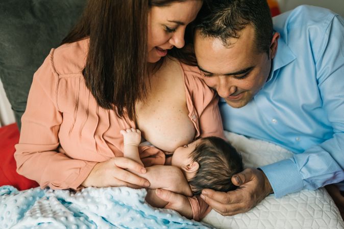 Mom near father breastfeeding at home
