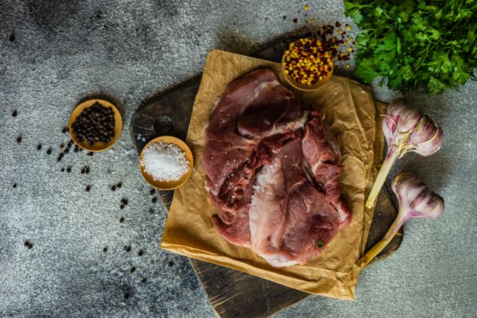 Top view of meat, spices and herbs on stone table with copy space