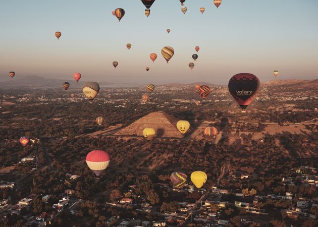 Cluster of hot air balloons in flight over pyramids in Teotihuacan Valley