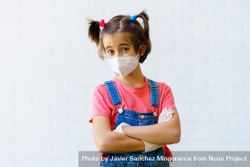 Cute child in overalls, gloves and facemask with arms crossed bDR8A5