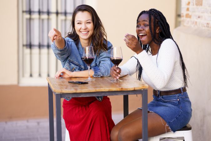 Female friends drinking red wine at an outdoor table at a restaurant