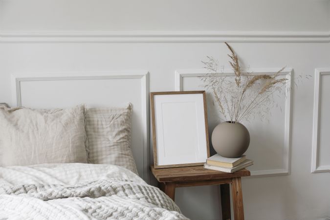 Bedside table with mockup poster, round vase with decorative reeds