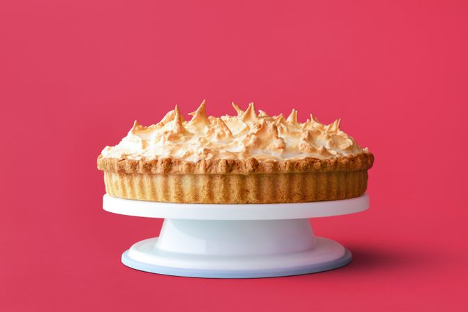 Homemade lemon meringue pie isolated on a pink background