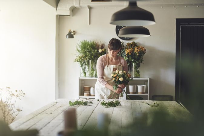 Florist creating beautiful bouquet in her shop