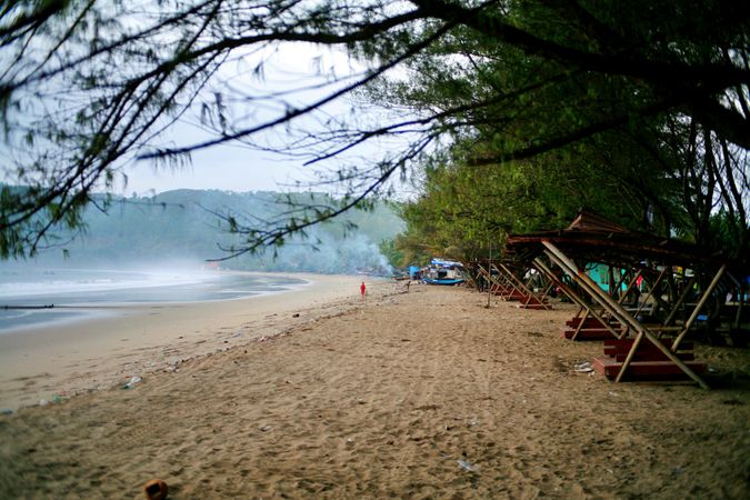 Quiet foggy beach in Indonesia with people walking in distance