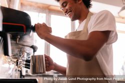 Happy young man preparing coffee at counter 5rNy35