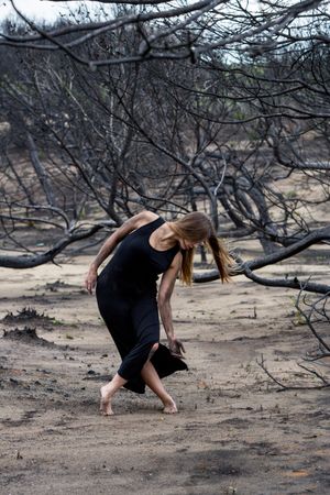 Woman dancing between dry trees