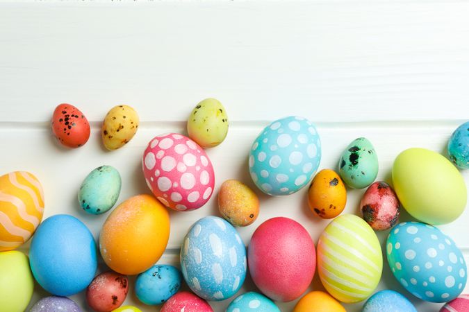 Decorative Easter eggs on wooden background, space for text. Top view