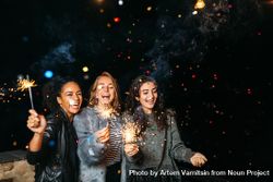 Multi-ethnic group of smiling women at a party with  sparklers 48AkKb