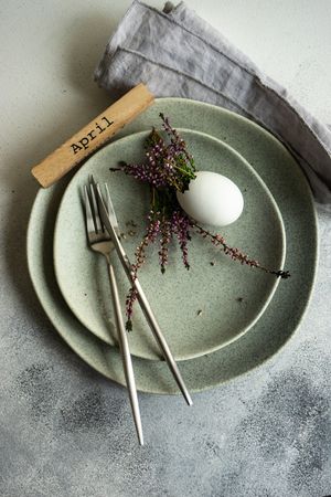 Top view of Easter table setting with egg and heather