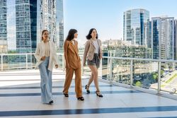Three businesswomen walking on a tower building terrace