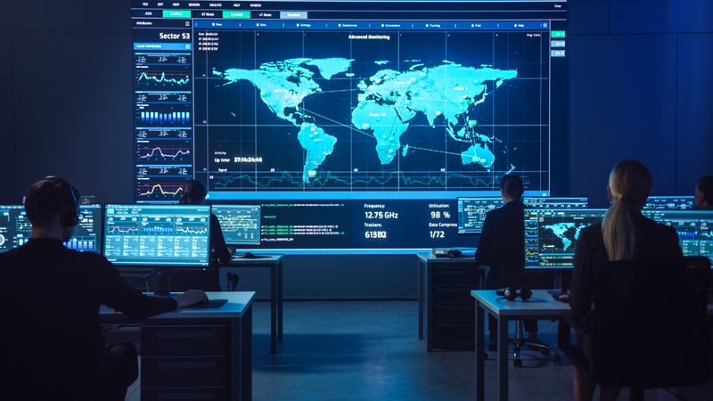 Experts Monitor Global Data on Multiple Screens in a High-tech Control Room, Optimizing Cybersecurity and Strategic Operations. the Collaborative Environment Enhances Decision-making and Innovation.