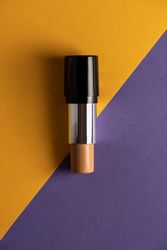 Concealer stick on modern background with geometric shapes.