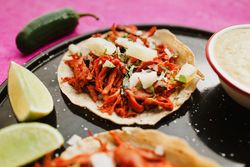 Pepper and lime near tacos al pastor and sauces
