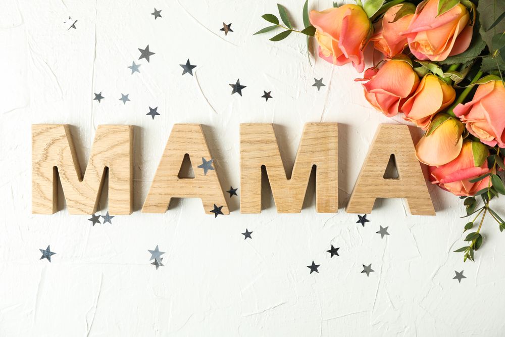 Composition with inscription Mom, pink roses and little stars on light background, top view
