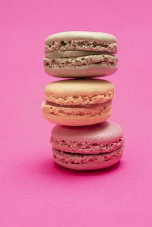 Stack of three French pastel macaroons on a pink table
