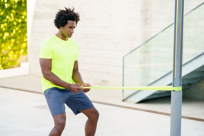 Man working out with pole and resistant bands outside