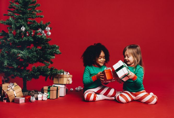 Playful girls swapping wrapped gift boxes