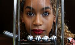 London - UK, April 4, 2016: Young woman with a Newton’s cradle pendulum