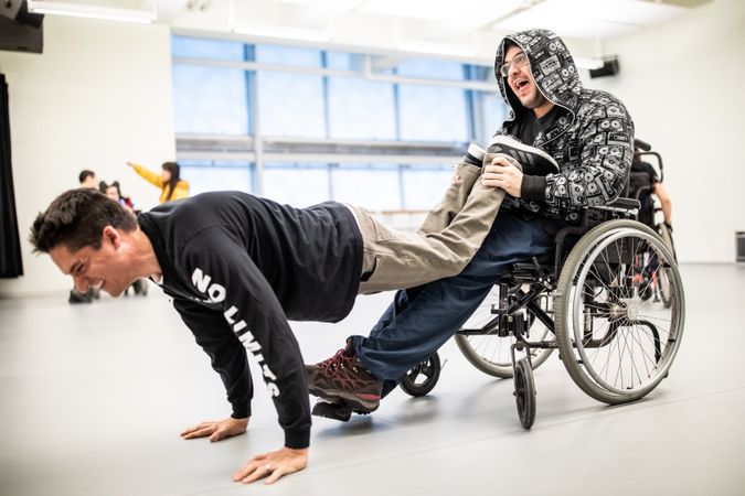 MONTREAL, QUEBEC, CANADA – April 14 2019- Man in wheelchair holding feet of man doing plant