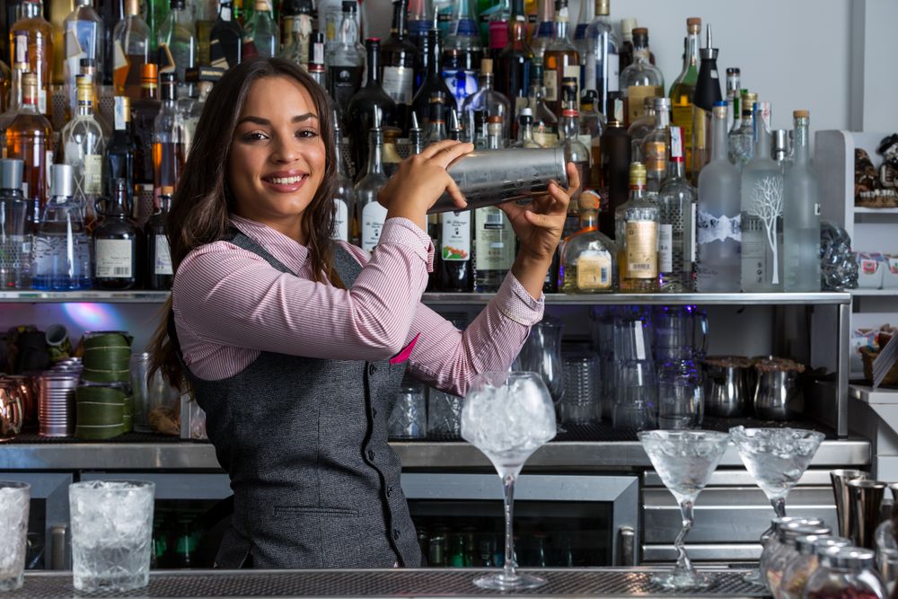 Smiling bartender shaking the cocktail mixer