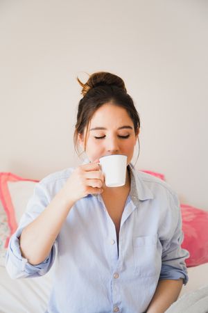 woman drinking coffee with closed eyes