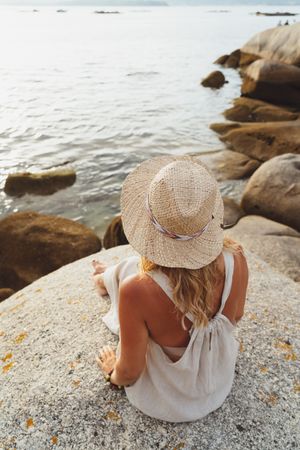 Carefree woman enjoying rest on coast near cliffs