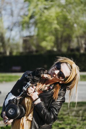 Woman showing dog with wheelchair on street