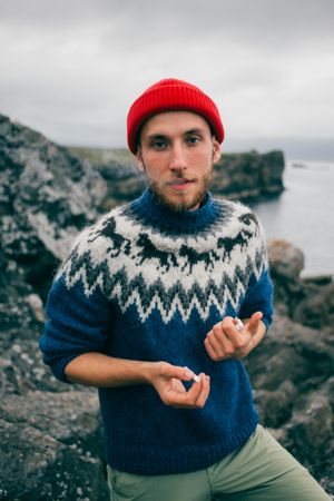 Portrait of man smoking cigarette in woolen sweater on overcast day