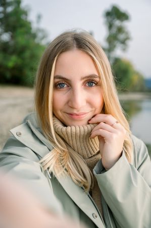 Smiling woman in coat looking at camera