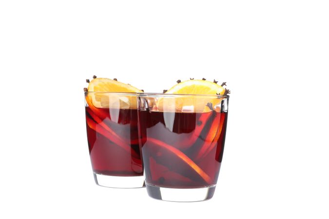Glasses of tasty mulled wine with orange isolated on plain background