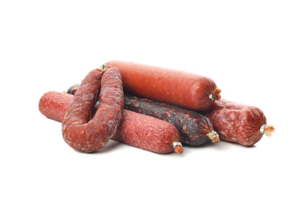 Large mixture of tasty cured meats in plain room