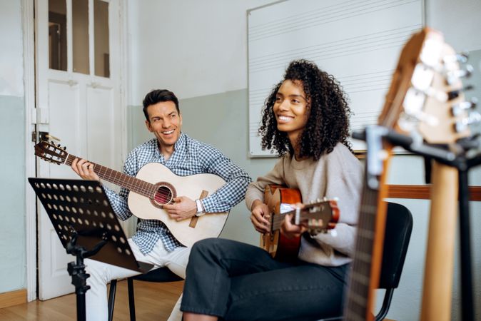 Man and woman playing guitar in studio