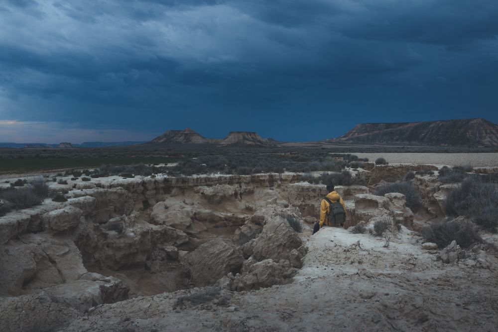Man standing on stone in desert hills